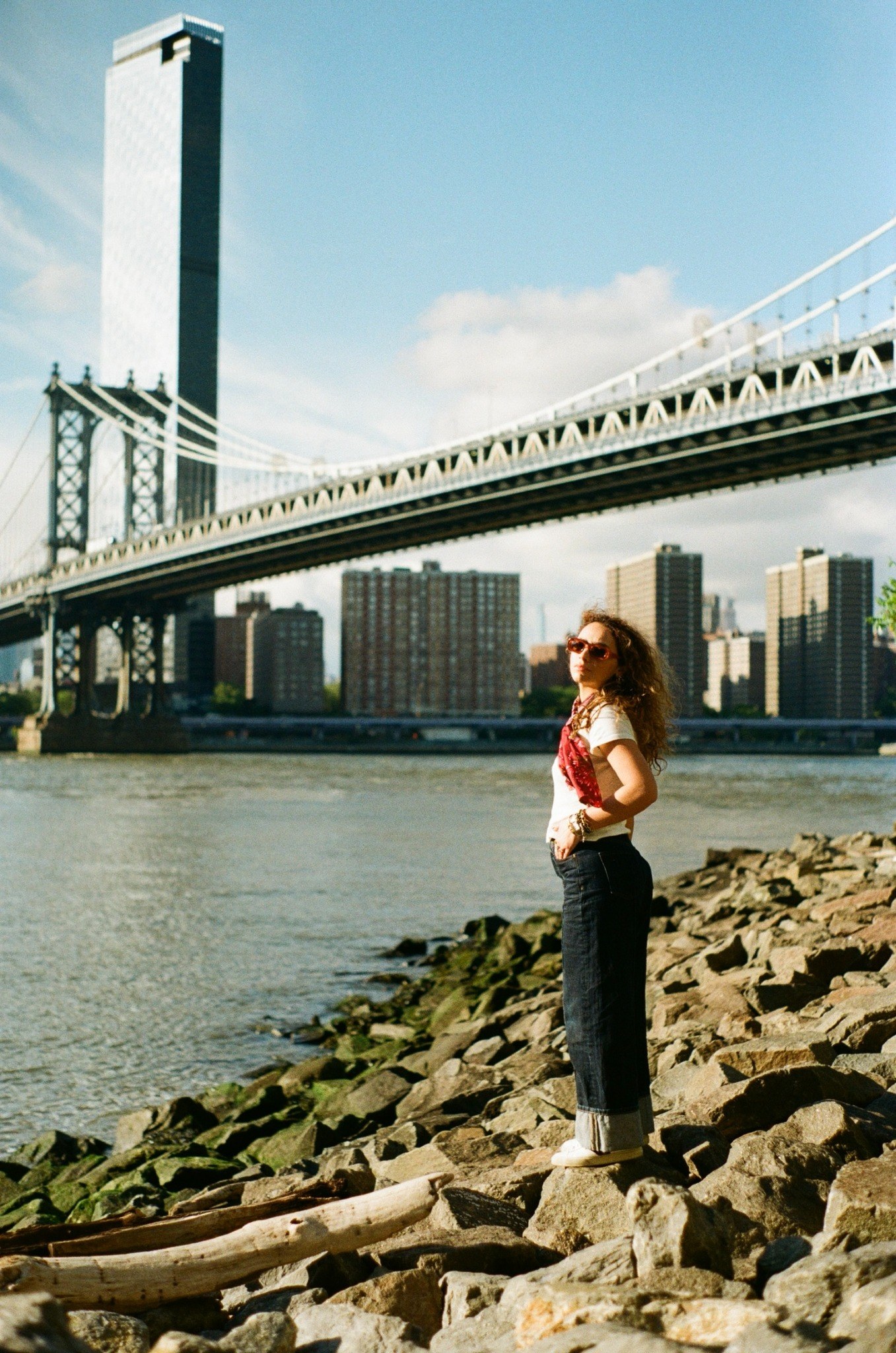 Abby standing by the waterfront beneath a bridge