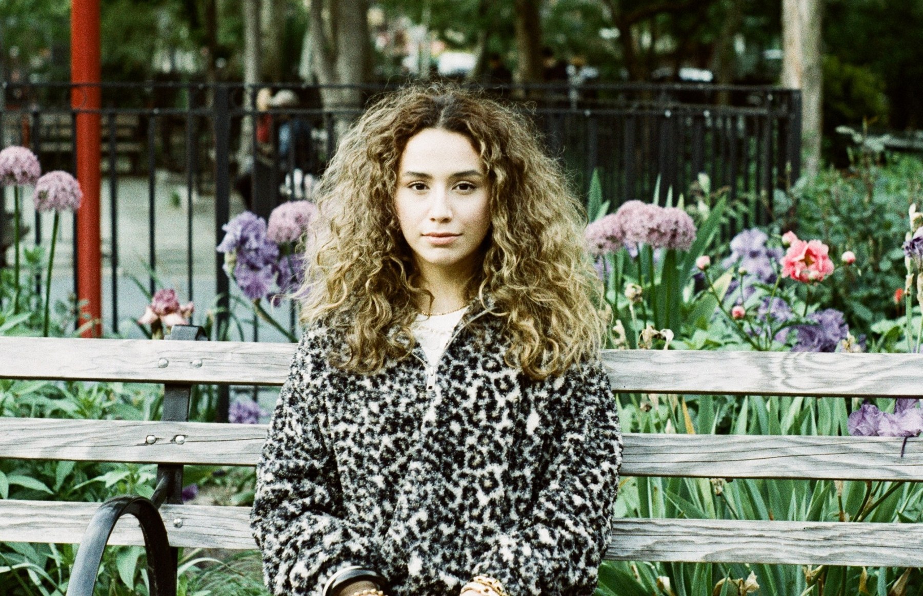 abby antoun seated outdoors, wearing a patterned jacket